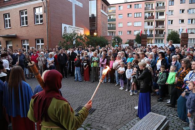 Wieczorne zgromadzenie uczestników Jarmarku św. Jakuba z pochodniami na placu.