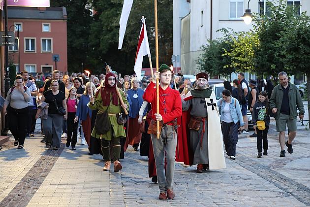 Historyczny pochód z flagami idący ulicą podczas Jarmarku św. Jakuba.