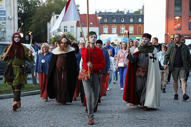 Ludzie w historycznych strojach idą w paradzie na Jarmarku św. Jakuba.