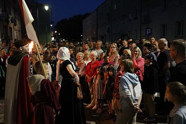 Tłum ludzi w historycznych strojach podczas nocnego Jarmarku św. Jakuba.
