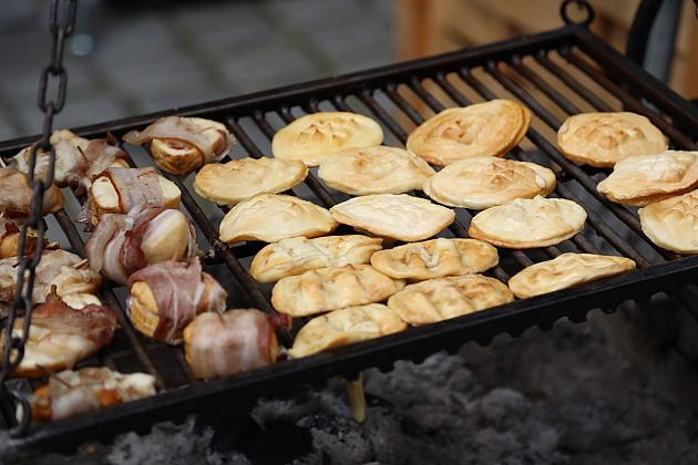 Grillowane mięso i pajdy chleba na ruszcie podczas jarmarku.