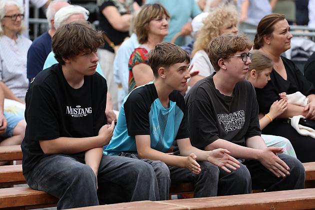 Młodzi ludzie siedzący na ławce podczas Jarmarku św. Jakuba.