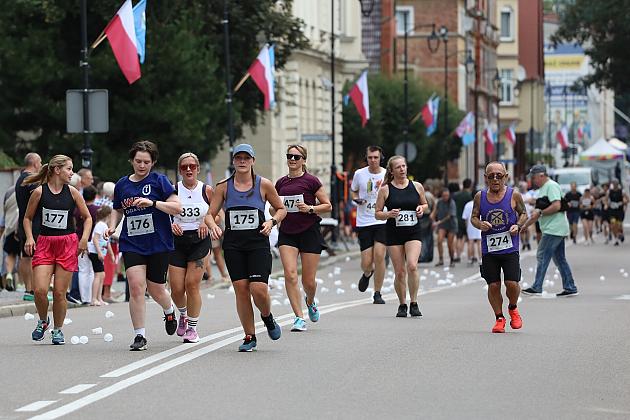 Grupa sportowców biegnąca ulicą podczas Dni Jakubowych.