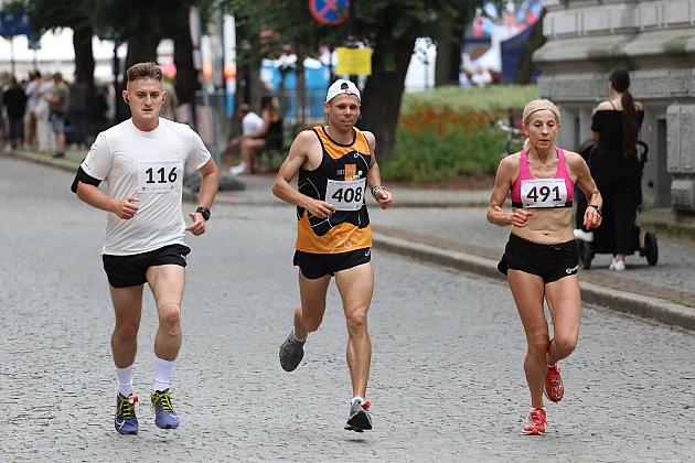 Trójka biegaczy rywalizuje w ulicznym Biegu św. Jakuba.