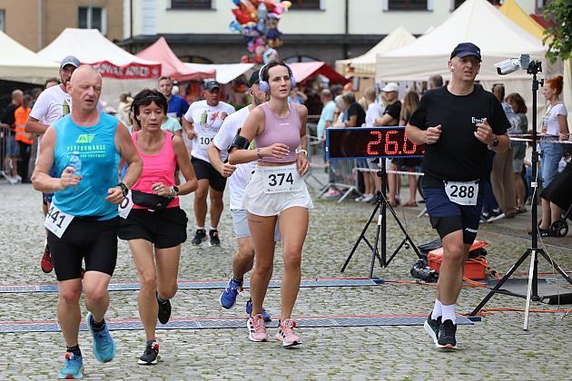 Biegacze uczestniczący w biegu sportowym podczas jarmarku.