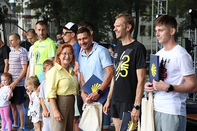 Uśmiechnięta grupa ludzi pozuje do zdjęcia podczas Jarmarku św. Jakuba.