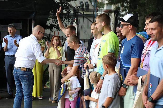 Mężczyzna w białej koszuli rozmawia z uczestnikami Jarmarku św. Jakuba.