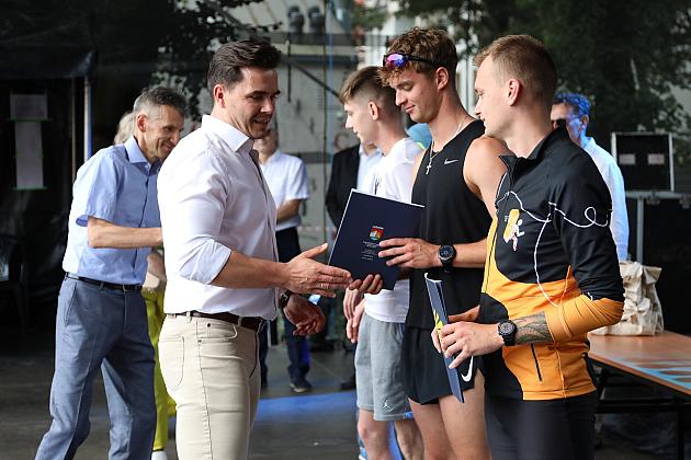 Mężczyzna wręcza dyplom uczestnikowi podczas Jarmarku św. Jakuba.