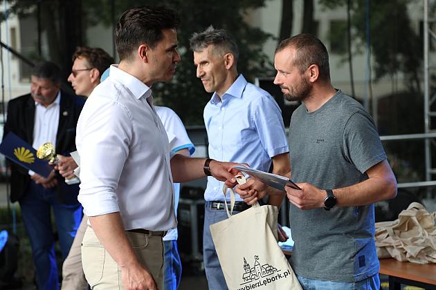 Mężczyzna wręcza dyplom uczestnikowi Jarmarku św. Jakuba.