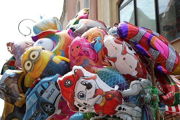 Kolorowe, foliowe balony z helem w kształcie postaci z bajek na jarmarku.