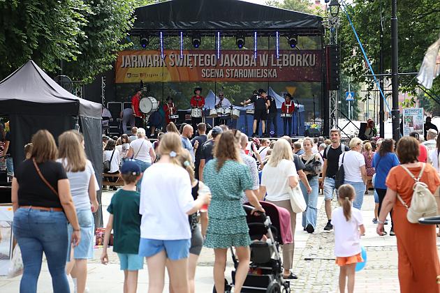 Ludzie spacerują przed sceną podczas Jarmarku św. Jakuba.