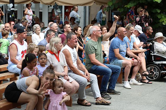 Ludzie siedzący na ławkach podczas plenerowego Jarmarku św. Jakuba.