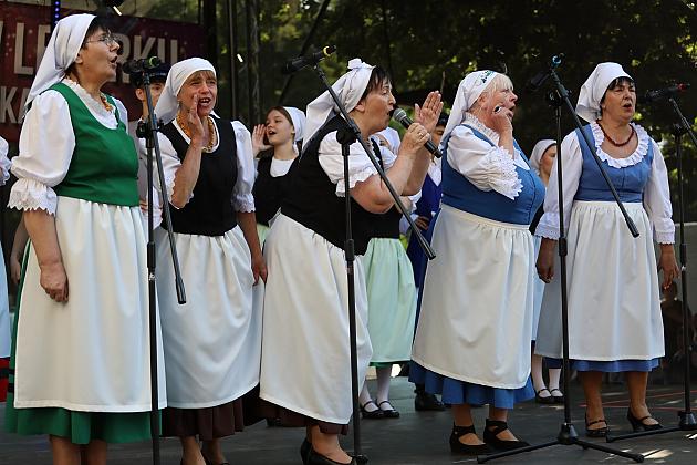 Kobiety w ludowych strojach śpiewają na scenie podczas Jarmarku św. Jakuba.