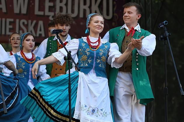 Artyści w tradycyjnych strojach ludowych tańczą na scenie podczas jarmarku w Lęborku.
