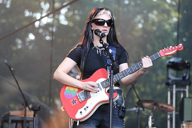 Muzyk gra na czerwonej gitarze elektrycznej podczas koncertu na Jarmarku św. Jakuba.