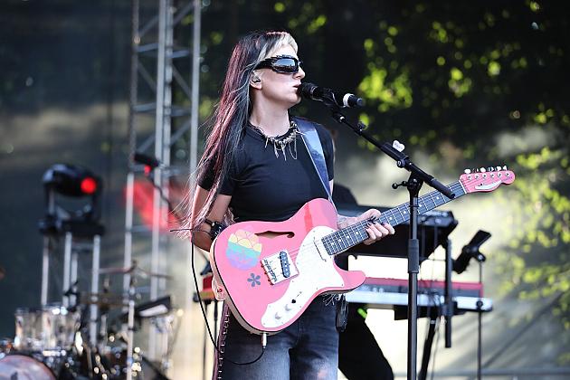 Gitarzystka gra na różowej gitarze elektrycznej na scenie podczas Jarmarku św. Jakuba.