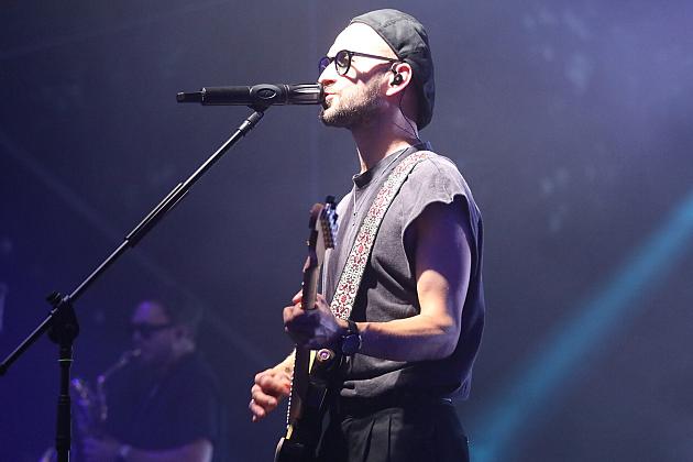 Wokalista grający na gitarze podczas koncertu na Jarmarku św. Jakuba.
