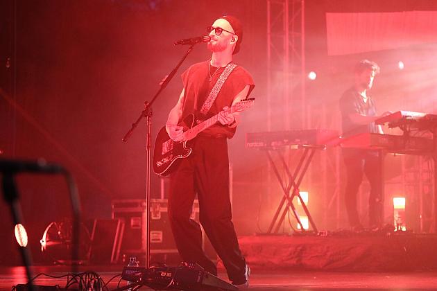 Gitarzysta na scenie Jarmarku św. Jakuba w czerwonym świetle.