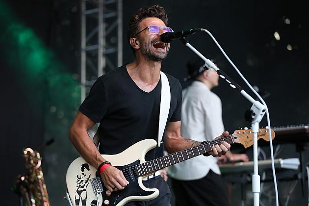 Wokalista gra na gitarze elektrycznej podczas koncertu na Jarmarku św. Jakuba.